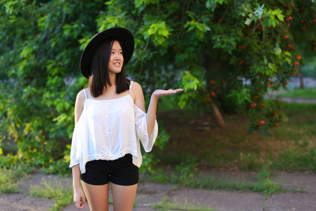 female hat nature summer sun sunset looks pleased. azitka woman black hair dancing around the trees looking at the camera. portrait.の写真素材