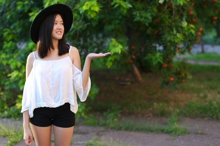 female hat nature summer sun sunset looks pleased. azitka woman black hair dancing around the trees looking at the camera. portrait.の写真素材