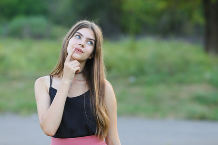Woman with long hair and beautiful eyes on a green background shows the different human emotions. Lady portrays happy wishesの写真素材