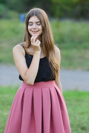 Woman with long hair and beautiful eyes on a green background shows the different human emotions. Lady portrays happy wishesの写真素材