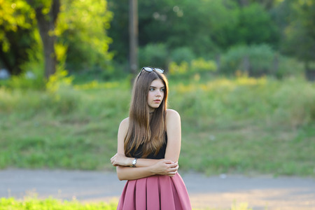 Woman with long hair and beautiful eyes on a green background shows the different human emotions. Lady portrays surprisingly, looks into the distance,の写真素材