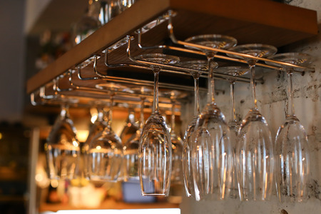 Many, a large number of wine glasses hanging upside down in cafe storaneの写真素材