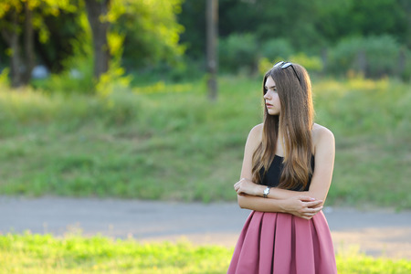 Woman with long hair and beautiful eyes on a green background shows the different human emotions. Lady portrays surprisingly, looks into the distanceの写真素材