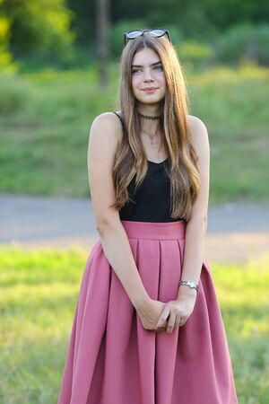 Woman with long hair and beautiful eyes on a green background shows the different human emotions. Lady portrays joy, bliss, pleasure, smileの写真素材
