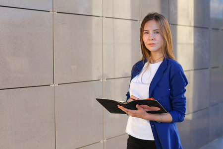 Hand lady press tauchpad keyboard on laptop. Young beautiful female business woman entrepreneur long hair wearing suit standing near center technology sunの写真素材