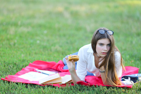 girl lying on the nature and eateth fast food. student working in the park and eat.の写真素材