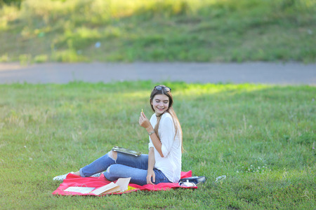 feminine working outdoors with papers in glasses. in the park for a laptop fast food snack and uses a tabletの写真素材