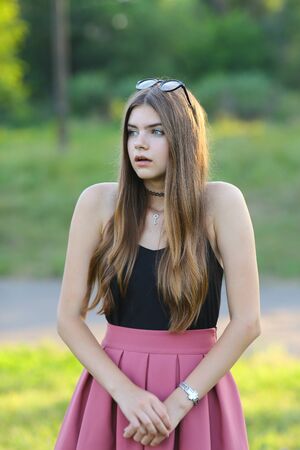 Woman with long hair and beautiful eyes on a green background shows the different human emotions. Lady portrays surprised, scaredの写真素材