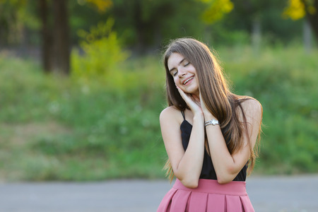 Woman with long hair and beautiful eyes on a green background shows the different human emotions. Lady portrays happy wishesの写真素材