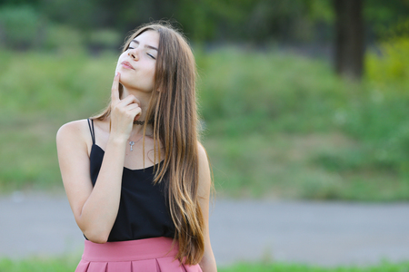 Woman with long hair and beautiful eyes on a green background shows the different human emotions. Lady portrays happy wishesの写真素材