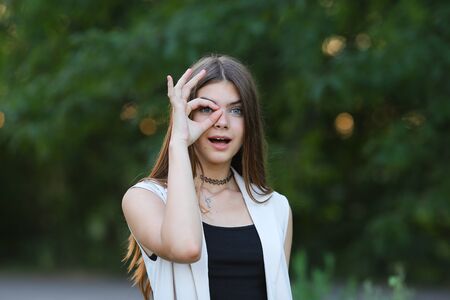 Woman with long hair and beautiful eyes on a green background shows the different human emotions. Lady portrays joy, lightness, ease, delight, happinessの写真素材