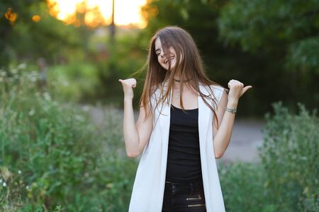 Woman with long hair and beautiful eyes on a green background shows the different human emotions. Lady portrays joy, lightness, ease, delight, happiness, Likeの写真素材
