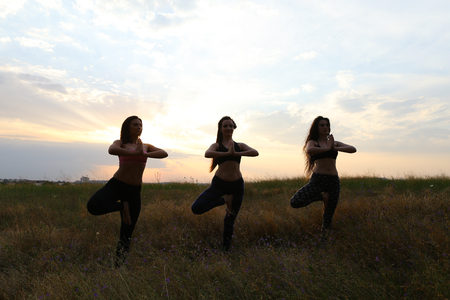 Beautiful woman doing yoga and meditating, doing morning exercises and setting yourself up for productive day, advertise sportswear or studio for fitness and exercise classes, perform breathing exercises. Girl with shoulder-length hair dressed in pink topの写真素材