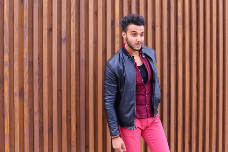 Successful Young Entrepreneur Arabian Man Poses For Photograph, Preens For Meeting, Wipes Glasses and Straightens Jacket and Hair, Smiles at Camera and Looks in Direction of Panel Against Backdrop of Wooden Stairs at Outdoor. Stylish Young Man With Dark Hの写真素材