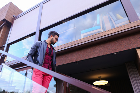Modern stylish man, students gathered to spend time at restaurant and decided to have dinner, arranged meeting with girl and is waiting for her at entrance to restaurant, poses for catalog of mens clothing brand, advertises glasses. Guy Has Dark Hair and の写真素材