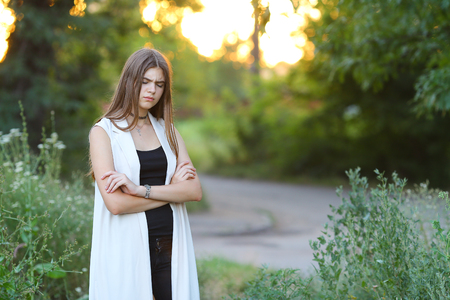 Woman with long hair and beautiful eyes on a green background shows the different human emotions. Lady portrays resentment, quarrel, sadnessの写真素材