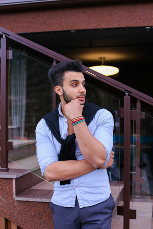 Serious student of Arabic businessman about something and remembers thinking, posing for catalog of brand of mens clothing, arranged meeting with friends, thinking where to go have fun on weekends. Handsome Muscular Guy Dressed in Black Classic Trousers, の写真素材