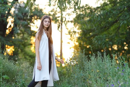 Woman with long hair and beautiful eyes on a green background shows the different human emotions. Lady portrays joy, lightness, ease, delight, happinessの写真素材