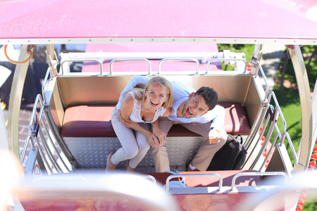 Lovers couple of beautiful people, boy and girl hugging, posing for photo, ride on ferris wheel, smiling, laughing and sit in booth ferris wheel on background of sky and trees at an amusement park outdoors. Girl with long blond hair dressed in white top aの写真素材