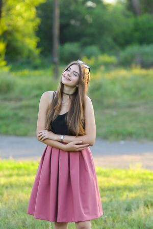 Woman with long hair and beautiful eyes on a green background shows the different human emotions. Lady portrays joy, bliss, pleasure, smileの写真素材
