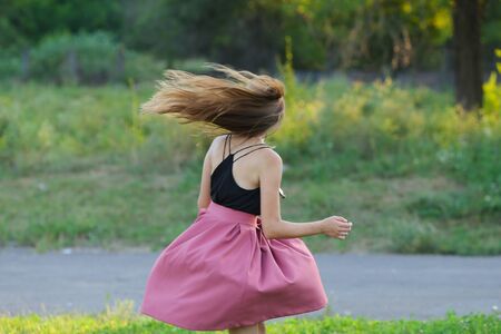 Woman with long hair and beautiful eyes on a green background shows the different human emotions. Lady portrays dancing, jumping, fun, happiness, smileの写真素材
