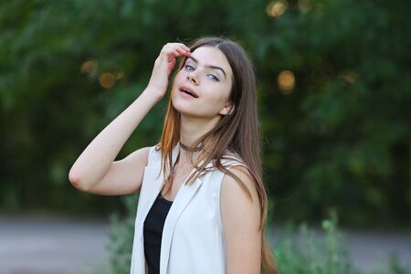 Woman with long hair and beautiful eyes on a green background shows the different human emotions. Lady portrays joy, lightness, ease, delight, happinessの写真素材