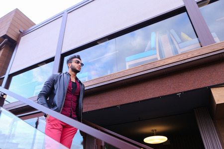 Modern stylish man, students gathered to spend time at restaurant and decided to have dinner, arranged meeting with girl and is waiting for her at entrance to restaurant, poses for catalog of mens clothing brand, advertises glasses. Guy Has Dark Hair and の写真素材