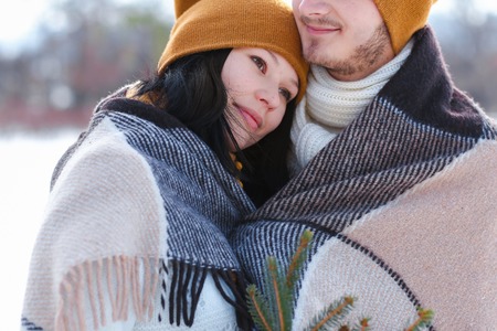 Close up Girl and guy european appearance hugs in winter white snow. Young couple man and woman love each other, show their sincere feelings. Concept of happiness, happy family life and love.の写真素材
