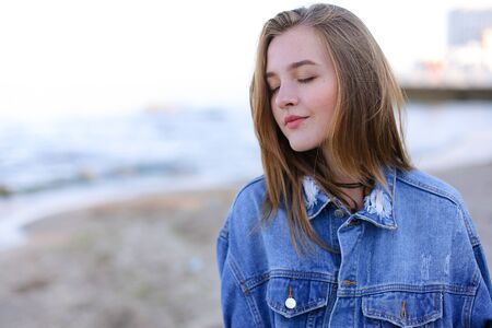 Pretty woman in high spirits looks into camera and smiles sweetly,の写真素材