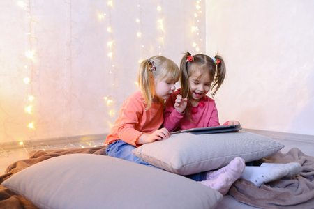 Concept of happy and carefree childhood, modern technologies and gadgets, bright and unforgettable New Years childrens emotions, Christmas gifts and Santa Claus, childrens entertainment and fun games, decor and bright festive interior.の写真素材