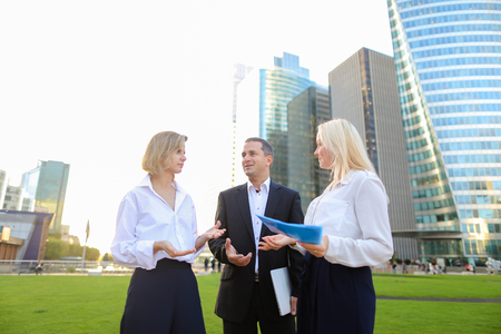 Financial analysts talking about crypto currency with tablet in  . Concept of  managing various aspects of money and speaking with boss. Colleagues speaking outside and smiling.の写真素材