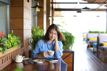 Female student chatting with friends by laptop at cafe.の写真素材