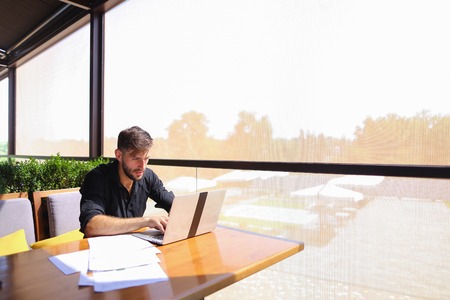 Tired quantity surveyor working at cafe table with diagram and statistic documents.の写真素材