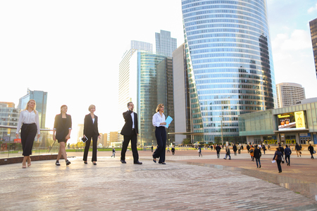 Gladden businesswoman going with blue document case and employees background,  . Concept of blonde female person in white shirt and successful career. Young blonde lady smiling and looking at camera.の写真素材