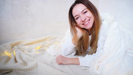 Marvelous girl in high spirits posing in camera and laughing, smiling and showing thumbs-up gesture in lens.の写真素材