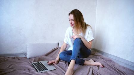 Successful young woman and mother loves work and uses laptop, smiling and looking at camera