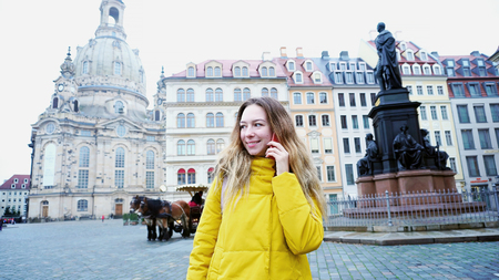 Young European-looking woman with long blond hair in cultural center of European city and stands in front of cameraの写真素材