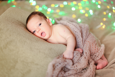 Little nice baby lying on blanket with glares in background. Concept of newborns.の写真素材