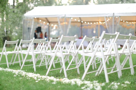 White chairs in park near restaurant. Concept of wedding day and decorations.の写真素材