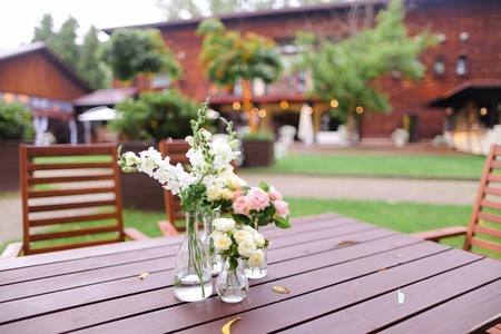 Flowers in vase on wooden table. Concept of restaurant and catering establishment.