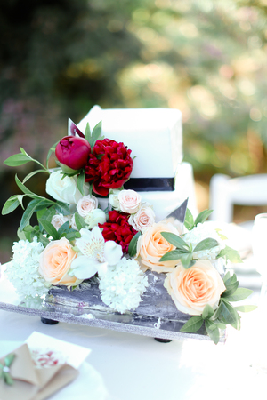 White nice wedding cake with red peony. Concept of bridal sweets.の写真素材