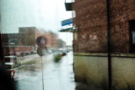 Bokeh street and house, cloudy weather. Concept of town and rainy weather.