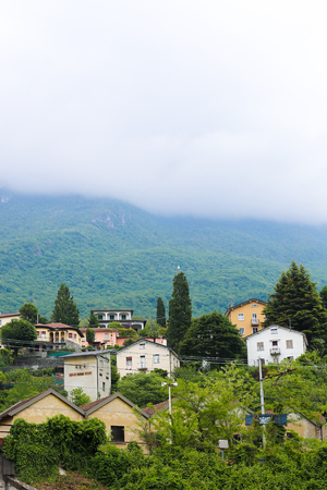 Italian village landscape with buildings and Alps Mountains in background. Concept of summer vacations, rural picturesque photo and countryside.の写真素材