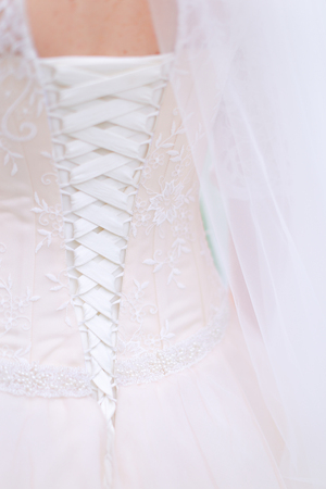 Closeup back view of bride white dress. Concept of wedding photo session.の写真素材