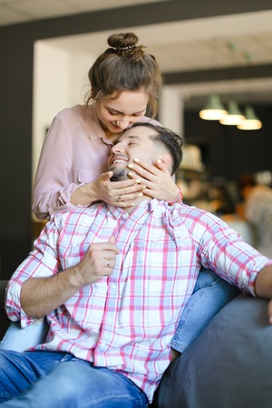 Young european wife kissing and hugging husband at home. Concept of spending time together,...