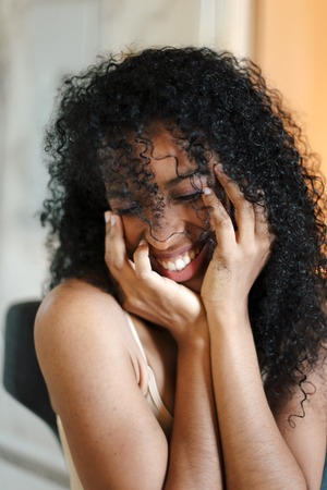 Close up portrait of smiling black girl with curly hair. Concept of afro american beauty and female person.の写真素材