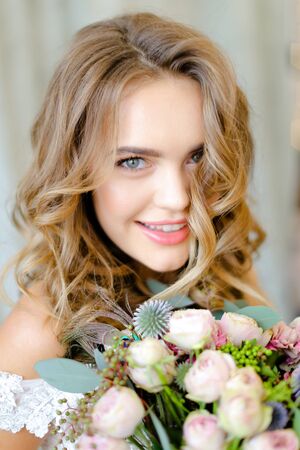 Close up portrait of young bride with bouquet at studio. Concept of bridal photo session and floristic art.の写真素材