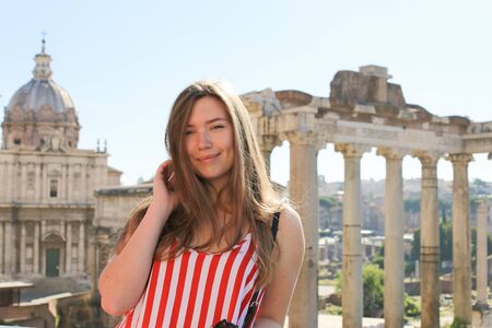 Young woman standing in ruins of Roman Forum background in Rome, Italy. Concept of antique european landmarks and last minute tours.の写真素材