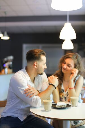 Young woman and man having lunch at cafe and holding hands. Concept of of love, catering establishment and happy couple.の写真素材