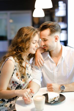 Young european woman and man having lunch at cafe, resting and drinking coffee. Concept of of love, catering establishment and happy couple.の写真素材
